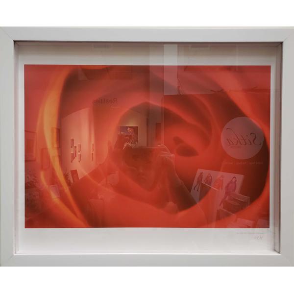 Framed digital print of a close-up of the center of a red flower. The frame is white and horizontally hung.