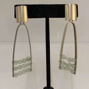 Elegant silver earrings with rectangular tops, featuring three rows of translucent light green beads.